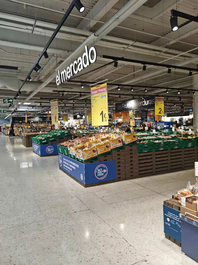 Black track lighting above a supermarket fresh produce display